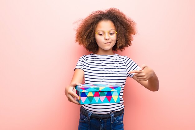 Afroamerikaner kleines Mädchen, das eine Geschenkbox hält