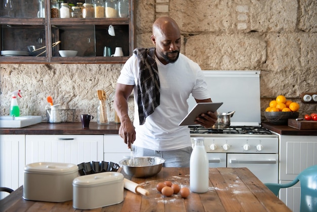 Afroamerikaner kocht, während er sich das Rezept online auf seinem Tablet ansieht