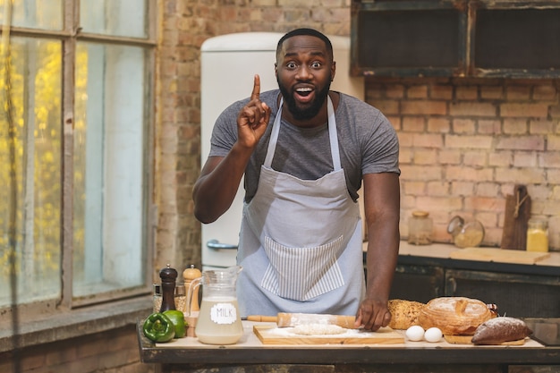 Afroamerikaner Mann, der Schürze und Backen trägt