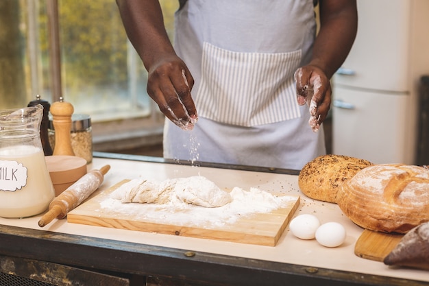 Afroamerikaner Mann, der Schürze und Backen trägt