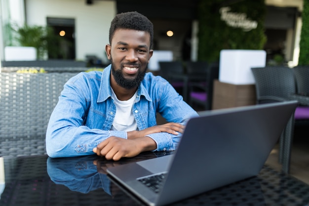 Foto afroamerikaner mit laptop in einem café