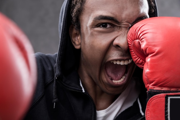 Afroamerikaner schlägt mit Boxhandschuhen