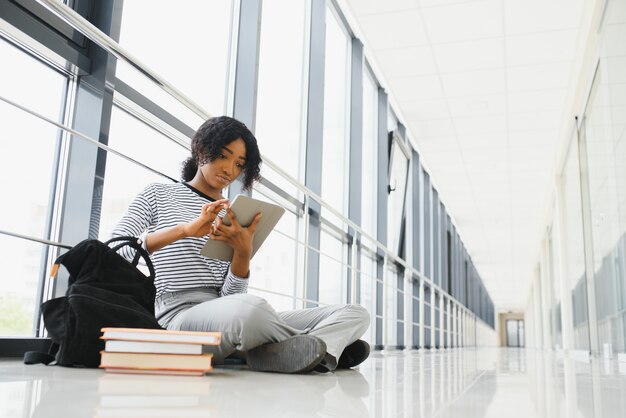 Afroamerikaner Student mit Notizbuch im Korridor in der Universität