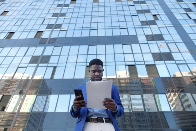 Afroamerikaner untersucht Papiere, die mit dem Telefon überprüft werden