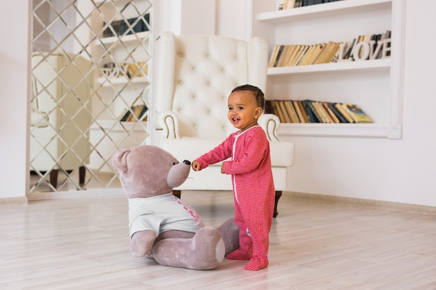 Afroamerikanerbaby mit Teddybär.