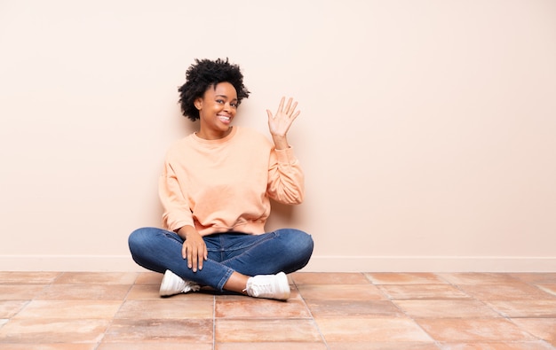 Afroamerikanerfrau, die auf dem Boden sitzt