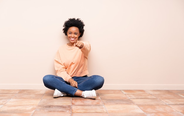 Afroamerikanerfrau, die auf dem Boden sitzt