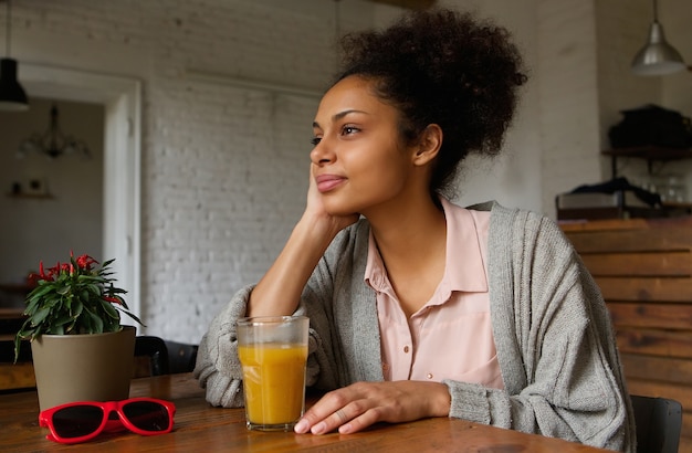 Afroamerikanerfrau, die zu Hause das Denken sitzt