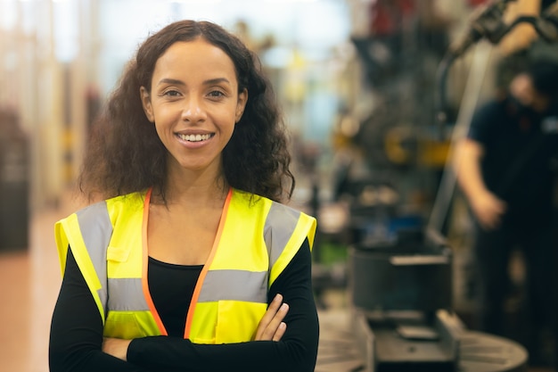 Afroamerikanerfrau glücklicher Arbeiteringenieur, der Lächelnarbeit in der Schwerindustriefabrik mit gutem Wohlfahrtskonzept arbeitet.