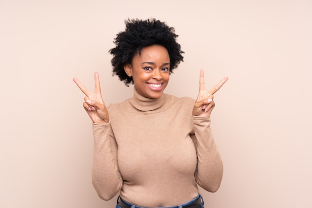 Afroamerikanerfrau über isoliert, die Siegeszeichen mit beiden Händen zeigt
