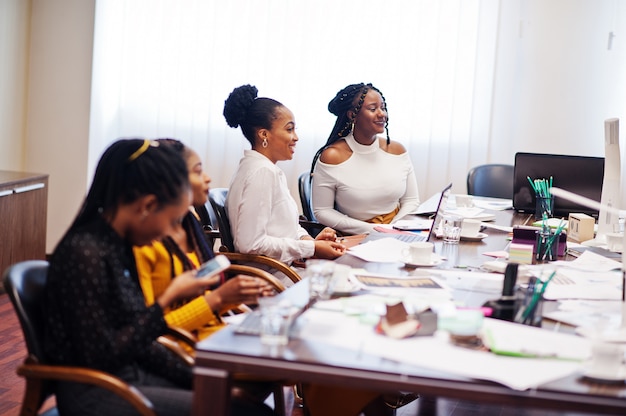 Afroamerikanerfrauenkolleginnen, Mannschaft von weiblichen Partnern der Verschiedenartigkeit im Büro sitzen am Tisch.