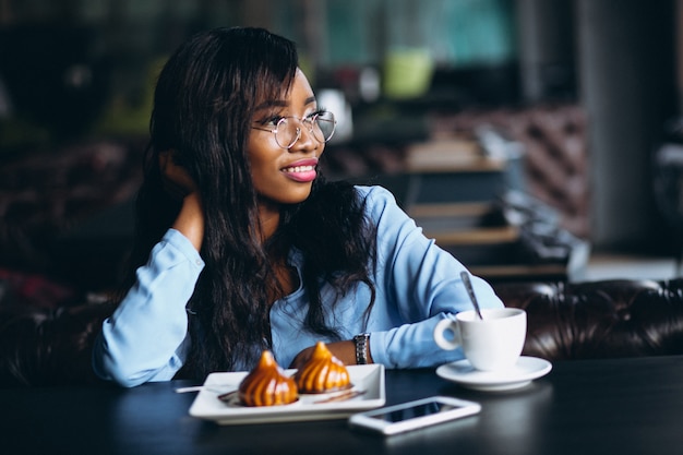 AfroamerikanerGeschäftsfrau, die in einem Café sitzt