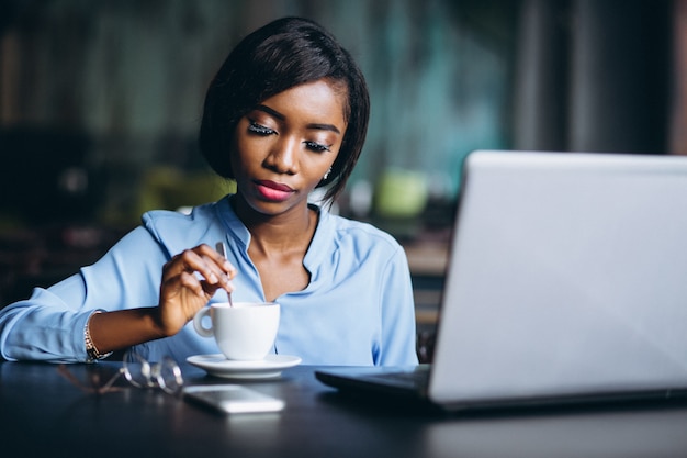 AfroamerikanerGeschäftsfrau mit Laptop in einem Café