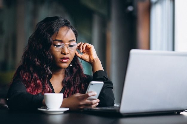 AfroamerikanerGeschäftsfrau mit Telefon und Laptop