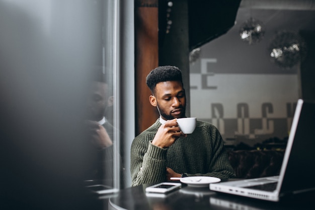 AfroamerikanerGeschäftsmann mit Laptop in einem Café