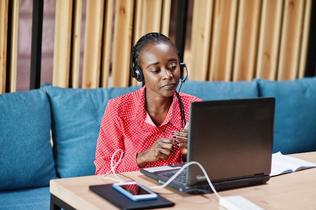 Afroamerikanerin arbeitet in einem Call-Center-Betreiber und Kundendienstmitarbeiter mit Mikrofon-Headsets, die am Laptop arbeiten