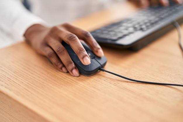 Afroamerikanerin benutzt Computermaus im Büro