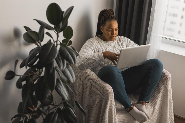 Afroamerikanerin, die Videoanrufe in sozialen Netzwerken und Verbindungen im Wohnzimmer tätigt