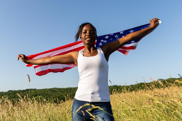 Afroamerikanerin in amerikanische Flagge gehüllt