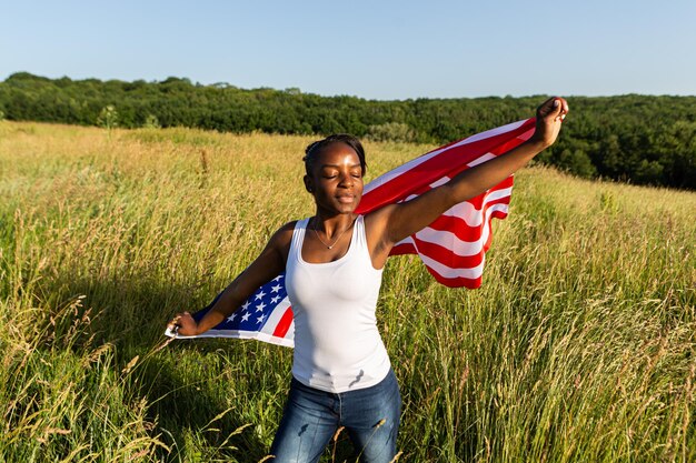 Afroamerikanerin in amerikanische Flagge gehüllt