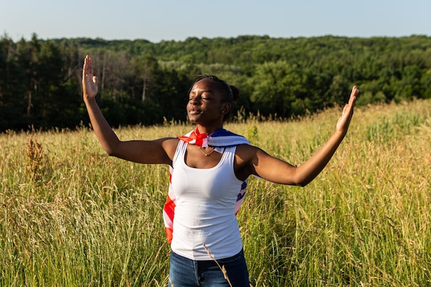 Afroamerikanerin in amerikanische Flagge gehüllt