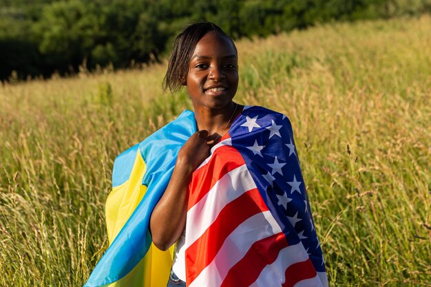 Afroamerikanerin in amerikanische und ukrainische Flagge gehüllt