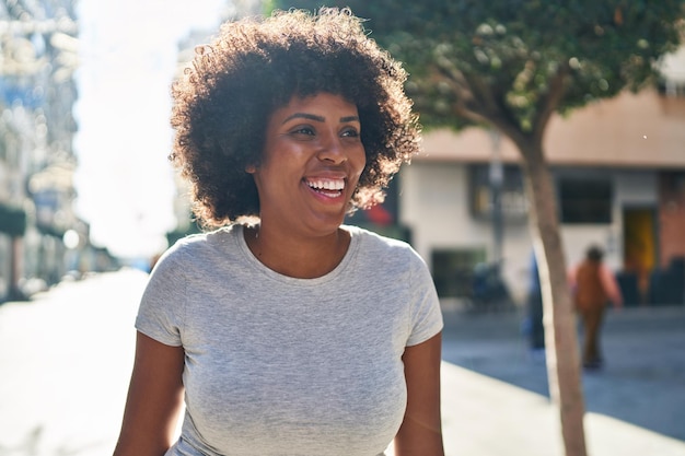 Afroamerikanerin lächelt selbstbewusst und schaut zur Seite auf die Straße