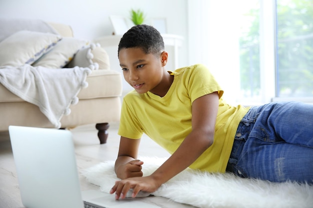 Afroamerikanerjunge mit Laptop zu Hause