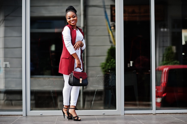 Afroamerikanermädchen mit Handtasche im Freien von Steets Stadt gestellt.