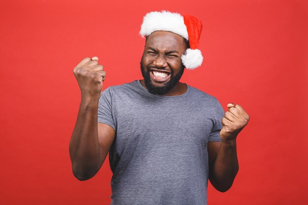 Afroamerikanermann im grauen T-Shirt und in der Weihnachtsmannmütze