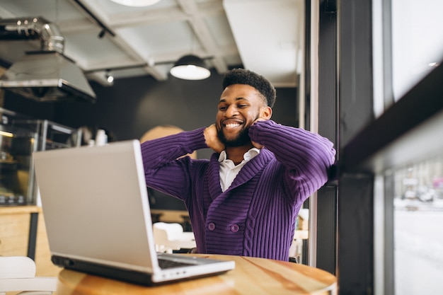 Afroamerikanermann mit Computer in einem Café