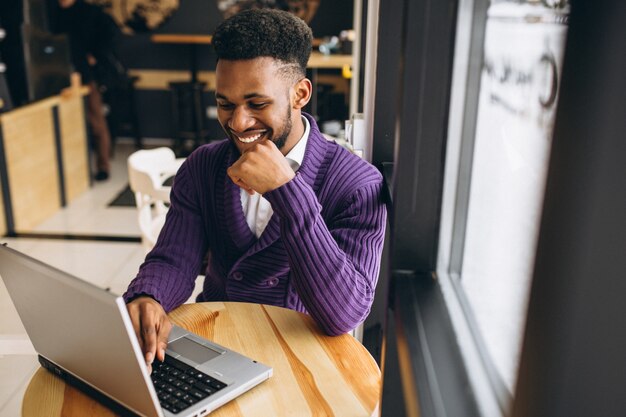 Afroamerikanermann mit Laptop in einem Café