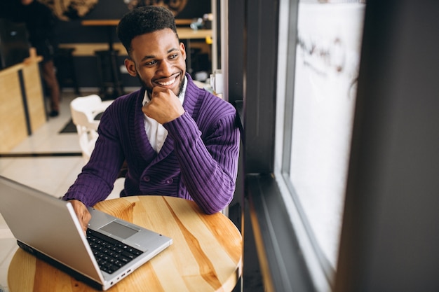 Afroamerikanermann mit Laptop in einem Café