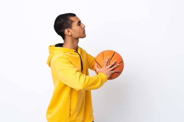 Afroamerikanermann über lokalisiertem weißem Hintergrund, der Basketball spielt