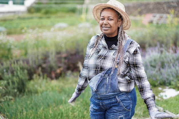 Afroamerikanische Bäuerin, die im Freien auf dem Landwirtschaftsfeld arbeitet