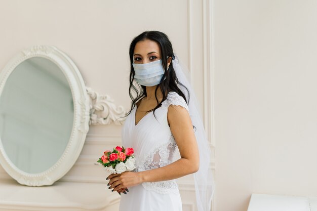 Afroamerikanische Braut in Kleid, Maske und morgens Vorbereitung auf die Hochzeit im Hotelzimmer