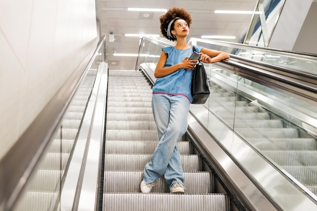 Afroamerikanische Dame auf U-Bahn-Rolltreppe