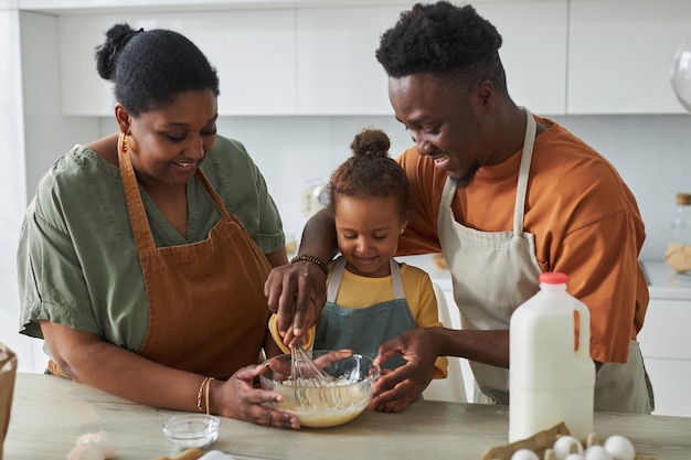 Afroamerikanische Eltern backen gemeinsam mit ihrem Kind in der Küche