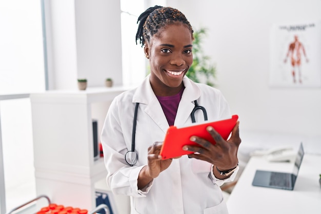 Afroamerikanische Frau in Arztuniform mit Touchpad in der Klinik