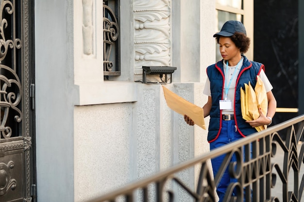 Afroamerikanische Postfrau liefert Pakete im Wohnviertel