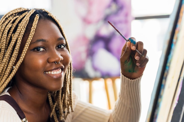 Afroamerikanische Studentin im Kunstunterricht inspiriert und malend