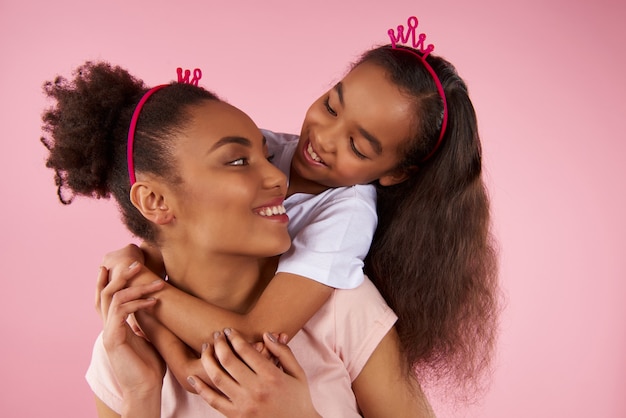 Afroamerikanische Tochter und Mutter in Scheinkronen