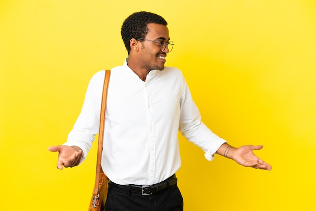 Afroamerikanischer Geschäftsmann über isoliertem gelbem Hintergrund mit Überraschungsausdruck beim Blick auf die Seite