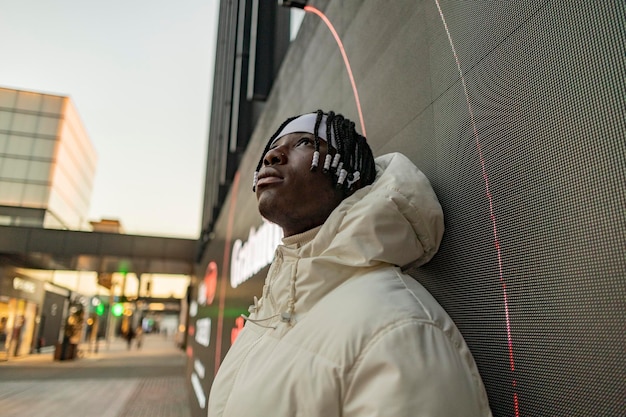 Afroamerikanischer junger Mann mit urbaner Kleidung in der Stadt