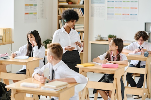 Afroamerikanischer Lehrer spricht mit Schülern im Unterricht in der Schule