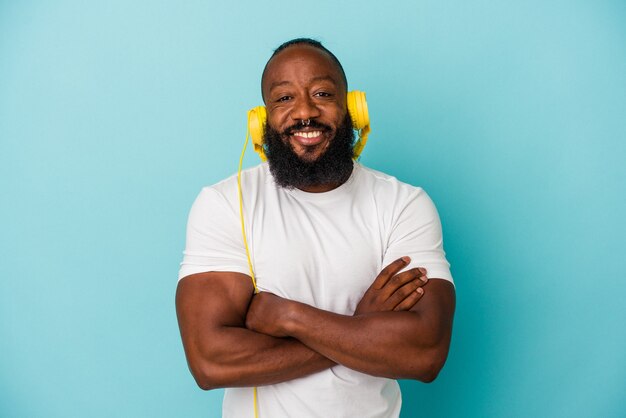 Afroamerikanischer Mann, der Musik hört, die auf blauem Hintergrund isoliert ist