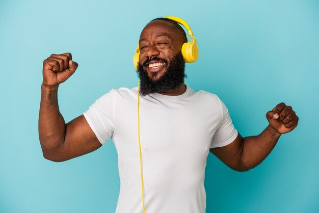 Afroamerikanischer Mann hört Musik isoliert auf blauer Wand