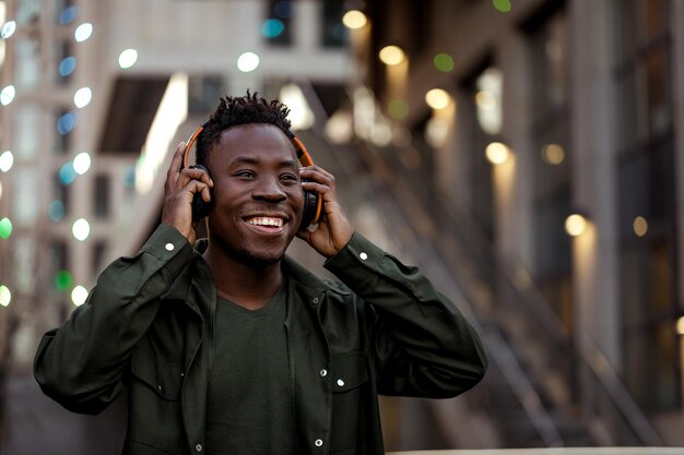 Afroamerikanischer Mann in drahtlosen Kopfhörern, der Musik hört