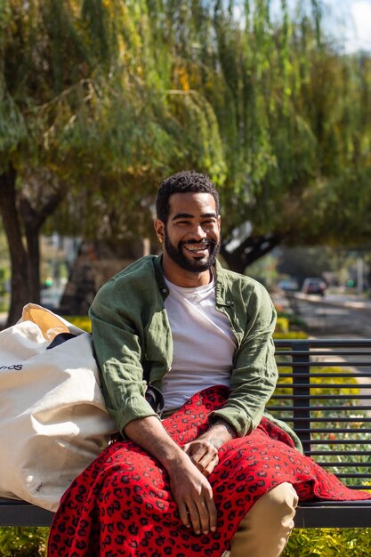 Afroamerikanischer Mann lächelt in einem Park sitzen