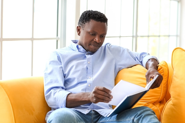 Afroamerikanischer Mann liest Buch zu Hause book